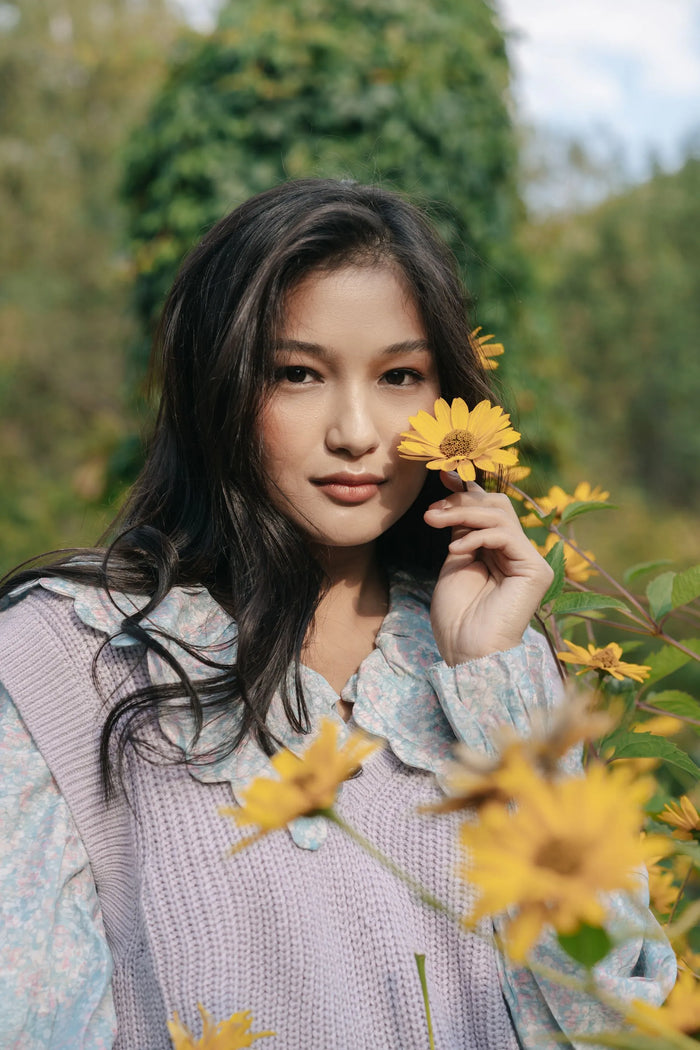 shallow depth of field portrait of a woman in a yellow flower field