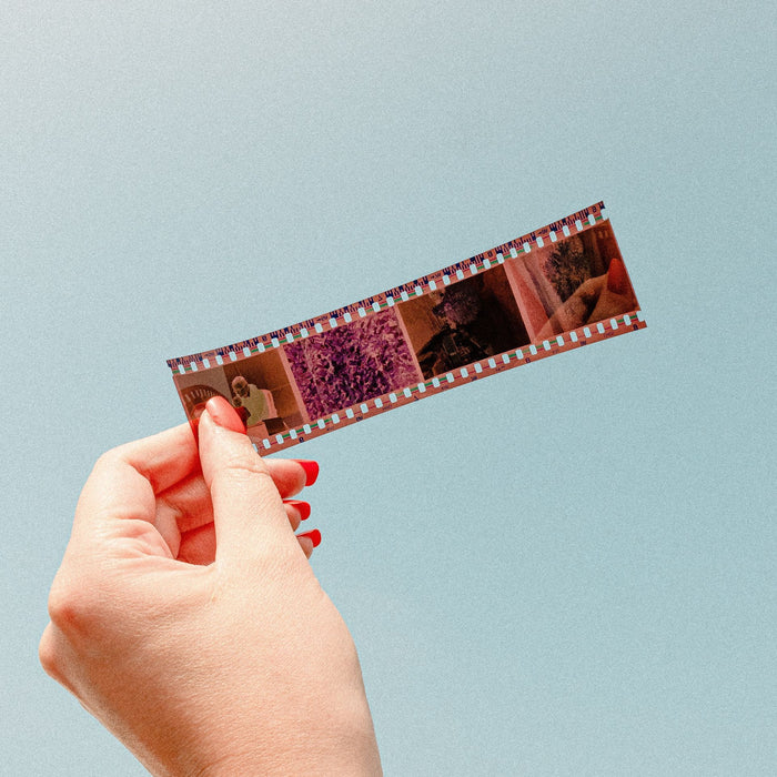 person's hand holding a 4-frame 35mm film negative