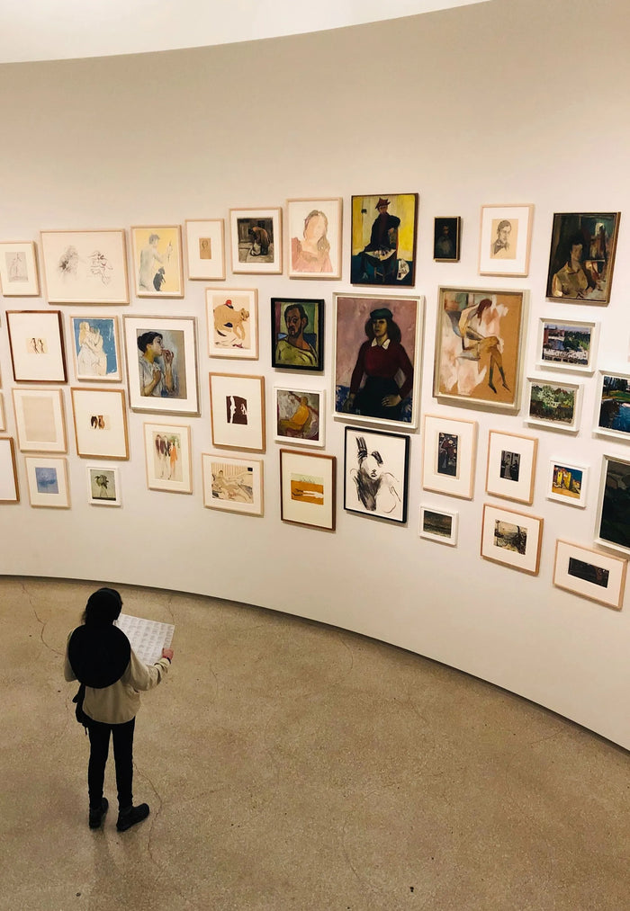 woman in a museum looking at a gallery wall